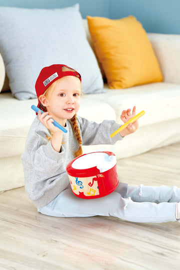 Little person playing the Hape Learn to Play Drum - The Toy Wagon